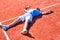 Full length of disappointed mature man lying by tennis racket on court during summer