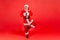 Full length elderly gray bearded santa claus meditating standing in tree pose and pressing hands, relaxing and resting before