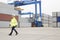 Full-length of female worker walking in shipping yard