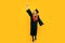 Full length, happy beautiful girl graduate student with diploma on yellow background. The concept of the ceremonial presentation