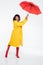 Full length image of Carefree african woman in raincoat