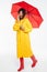 Full length image of confused african woman in raincoat