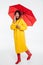 Full length image of confused african woman in raincoat