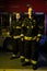 Full-length image of two firefighter looking into camera near fire truck,