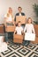 Full-length image of young married couple with children with cardboard boxes in their hands standing