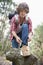 Full length of male backpacker tying shoelace in forest