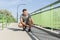 Full length of male jogger tying shoelace on bridge