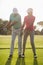 Full length of mature male golf player teaching woman