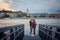 Full-length outdoor shot of the loving couple rubbing noses on the iron pier near River Danube in Budapest, Hungary.