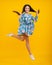 Full length overjoyed teenager kid girl 12 13 14 year jumping old  on yellow background studio. Funny jump