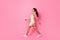 Full length photo of adorable pretty girl dressed yellow sarafan walking looking empty space isolated pink color