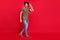 Full length photo of amazing guy came party say hi friends wear casual outfit isolated on red background