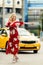 Full-length photo of blonde in red dress stopping taxi on summer