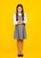 Full length photo of brunette teen girl wear casual clothes isolated on yellow background. Angry teenager girl, upset