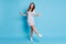 Full length photo of charming carefree girl stand tiptoe dance space wear dotted mini dress sneakers  blue color