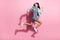 Full length photo of charming frightened lady wear striped dress jumping running fast looking back  pink color