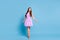 Full length photo of charming lady step flirty pose look camera wear purple dress stilettos isolated blue color