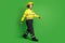 Full length photo of cheerful cute young fire lady workwear yellow helmet walking looking empty space isolated green