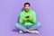Full length photo of cheerful impressed guy dressed neon sweatshirt enjoying playstation isolated violet color