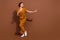Full length photo of cheerful positive dreamy woman look empty space dance enjoy isolated on brown color background