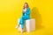 Full length photo of clever pretty woman wear blue stylish suit sit on white cube read email on smartphone isolated on