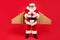 Full length photo of cool funky aviator santa claus in cap hat give craft package to kids in christmas night wear belt