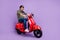 Full length photo of crazy happy cheerful young man wear sunglass ride bike isolated on violet color background