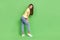 Full length photo of cute nice lady stand empty space fitting room choose quality jeans trousers  on green color