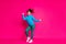 Full length photo of excited lucky young lady wear blue sweater dancing rising fists isolated bright pink color