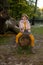 Full-length photo of a funny child girl riding a tree in an autumn Park. Kid fun and fantasy, ability to play. Dream of becoming a