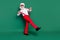 Full length photo of funny funky senior guy wear x-mas outfit glasses adjusting suspenders walking empty space isolated