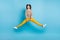 Full length photo of funny young lady wear ornament sweater jumping legs sides isolated blue color background