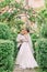 Full-length photo of the hugging newlyweds under the roses arch.