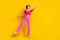 Full length photo of impressed nice carefree woman wear pink knit top pants jumping look empty space isolated on yellow
