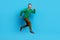 Full length photo of mature nice mister energetic running jumping rush dressed stylish green outfit isolated on blue