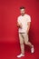 Full length photo of optimistic man in striped t-shirt smiling a