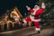 Full length photo of overjoyed grandfather santa enjoy dancing chilling evening evergreen lights outdoors