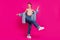 Full length photo of positive cool dreamy woman look empty space dance nice isolated on magenta color background