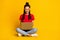 Full length photo of positive dark skin lady sit floor use laptop crossed legs isolated on yellow color background