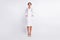 Full length photo of pretty charming young lady physician dressed uniform running standing arms pockets isolated white