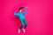 Full length photo of pretty funky young woman dressed blue hoodie dancing standing tiptoes isolated vibrant pink color