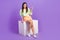 Full length photo of pretty girl wear pullover sit on platform directing at discount empty space isolated on violet