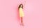 Full length photo of pretty person dancing look empty space have great time isolated on pink color background