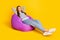 Full length photo of rest brunette young lady sit sleepy wear pullover jeans sneakers isolated on yellow color