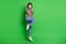 Full length photo shiny excited young lady dressed colorful pullover jumping high arms cheekbones isolated green color