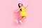 Full length photo of shiny funky school girl wear yellow dress eyewear jumping pointing empty space isolated pink color