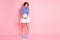 Full length photo of shy adorable lady hold hands wear striped shirt mini skirt footwear isolated pastel pink color