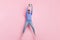 Full length photo of strong funny guy dressed blue pullover jumping high catching ball isolated pink color background