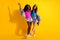 Full length photo of two brunette young women good mood summer weekend  on yellow color background