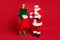 Full length photo of two men santa claus elf hold sack present wear x-mas costume coat cap footwear isolated red color